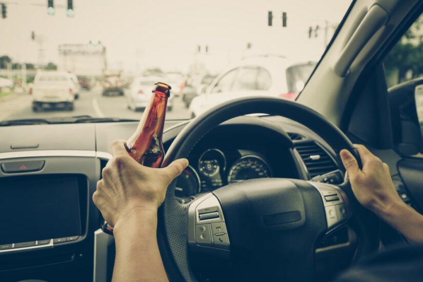DUI Law Person holding an opened beer bottle while driving